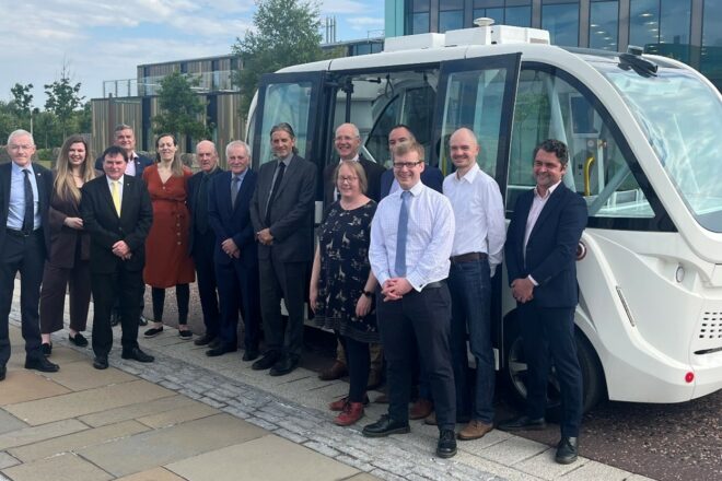 Image of the HITRANS Board members beside a bus