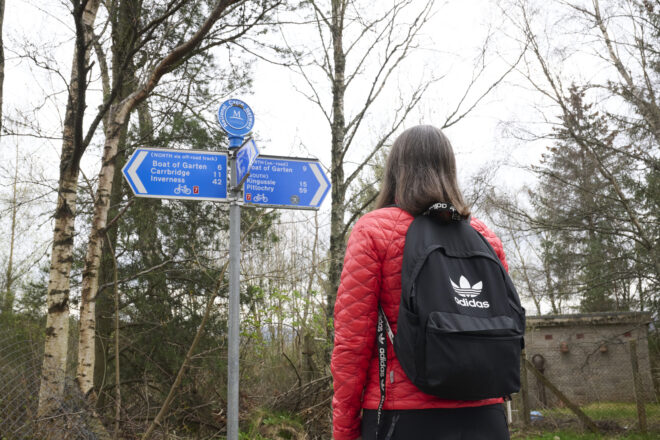 Person looking at a selection of directional route signs