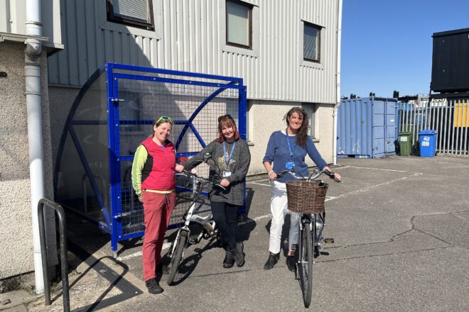 Sheila Wickens (HITRANS) and Tammy Campbell and Jaci Douglas from CALA with the new secure cycle shelter at the CALA office in Inverness