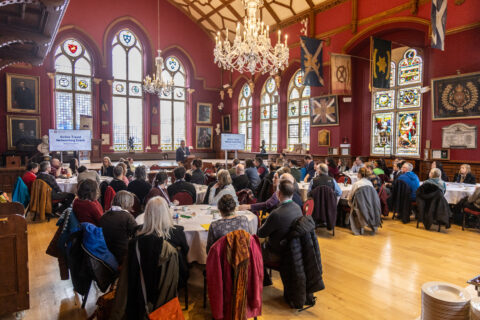 Image of a full room of guests in a conference hall