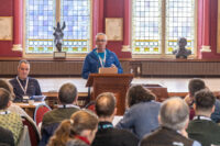 Image of George Ewing speaking at an lectern