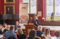 Image of Simon Erhardt speaking at a lectern 