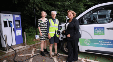 Image of HITRANS staff and Cabinet Secretary for Transport Fiona Hyslop beside an EV charger in Argyll and Bute