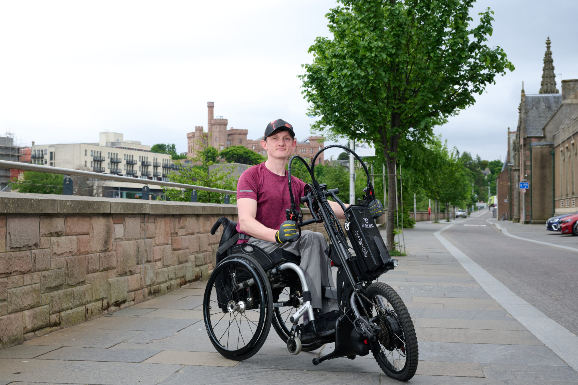 Grzegorz Faryno with his wheelchair accessory Beside the river Ness.